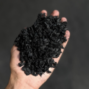British-made biochar held by hand for use in compost and soil improvement.