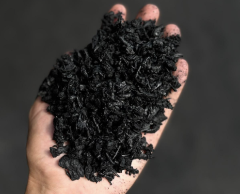 British-made biochar held by hand for use in compost and soil improvement.