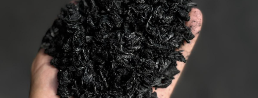 British-made biochar held by hand for use in compost and soil improvement.